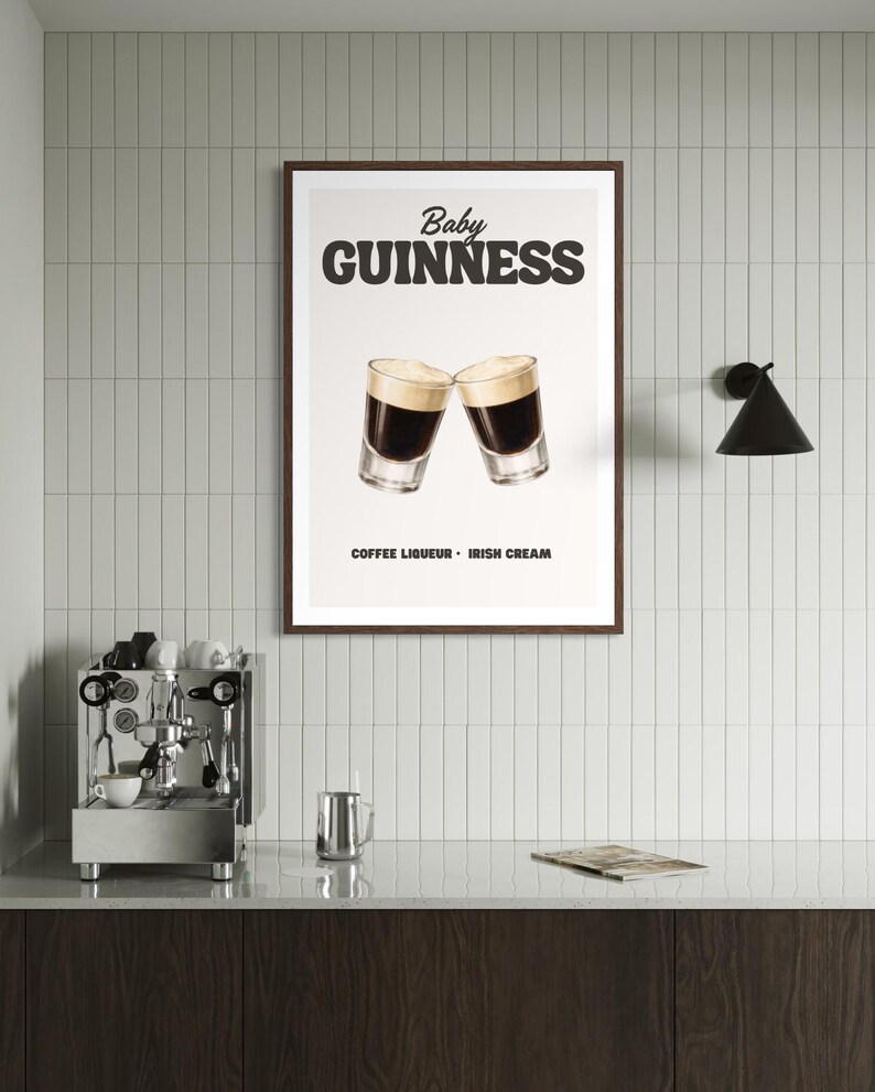 Puede incluir: Un cartel enmarcado con las palabras "Baby Guinness" sobre dos vasos de chupito llenos de un l&iacute;quido oscuro y cubiertos con espuma cremosa. El texto "Coffee Liqueur - Irish Cream" est&aacute; debajo. El cartel est&aacute; en una cocina.