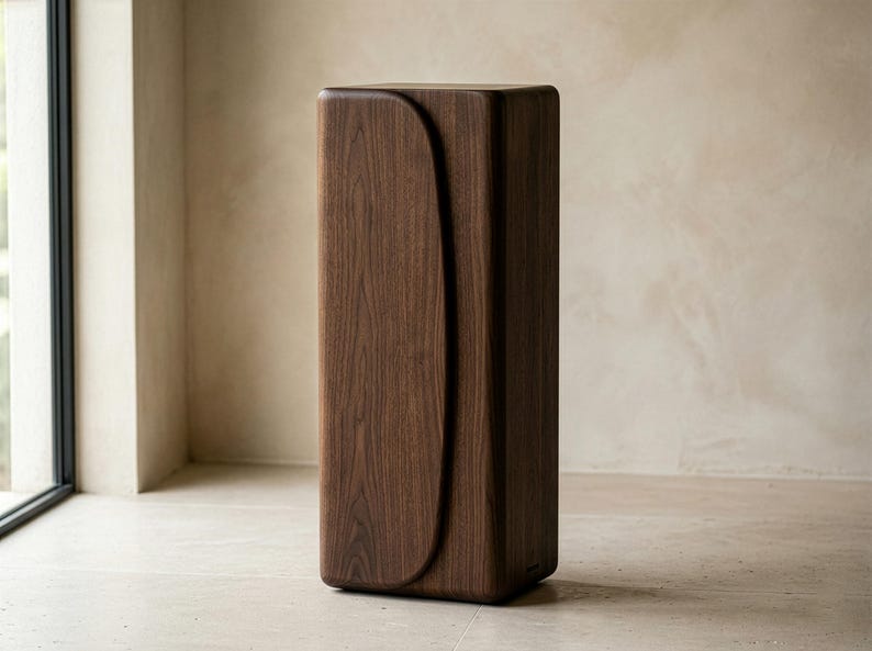 Op de afbeelding: Een hoge, donkerbruine houten kast met een gebogen ontwerp aan de voorkant. De kast is rechthoekig met afgeronde randen en staat op een lichtgekleurde vloer. De houtnerf is zichtbaar. Hoogte ongeveer 100 cm.