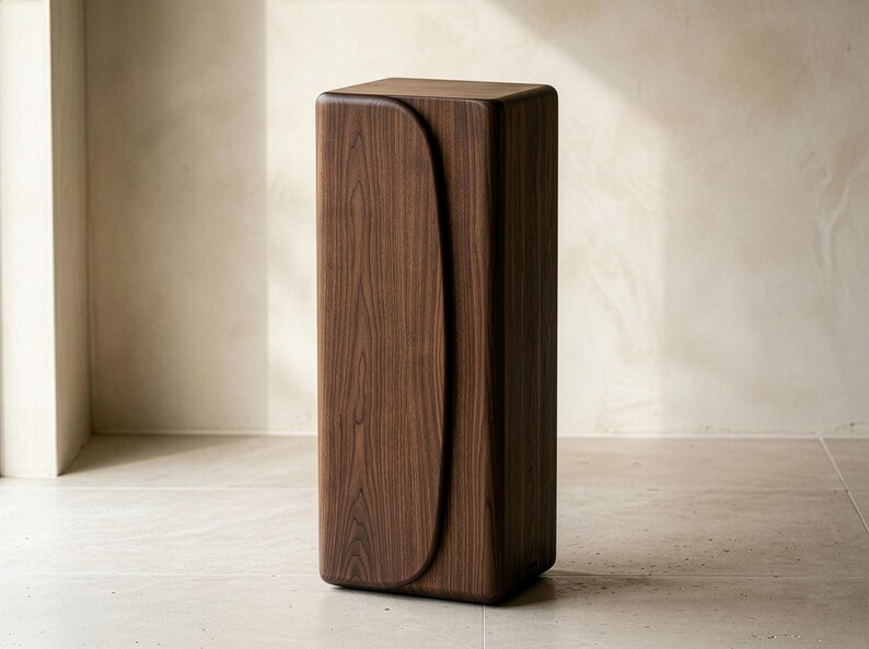 Op de afbeelding: Een hoge, rechthoekige houten kast met een gebogen ontwerp aan de voorkant. De kast is gemaakt van donkerbruin hout en heeft een gladde, gepolijste afwerking. Het ontwerp is een moderne, minimalistische stijl.