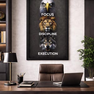Puede incluir: Un póster motivacional enmarcado con las palabras "Focus", "Discipline" y "Execution" sobre imágenes de un águila, un león y un lobo. El póster está en un entorno de oficina moderno con escritorio, silla y portátil.
