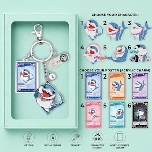 Pode incluir: Um conjunto de porta-chaves com um pendente de personagem de tubarão, um cartão acrílico retangular com a etiqueta JEFF, um pequeno pendente com a letra A e um pendente em miniatura de comando de jogo. Inclui guia de seleção para seis variantes.