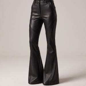May include: Black high-waisted pants with a smooth, leather-like finish. These trousers feature a fitted silhouette through the hips and thighs, transitioning into a flared leg design with prominent vertical seam detailing along the front panels.