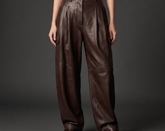 May include: High-waisted dark brown trousers crafted from a smooth material with a leather-like finish. These wide-leg pants feature a front zipper closure, belt loops, side pockets, and visible seam detailing along the legs and hips.