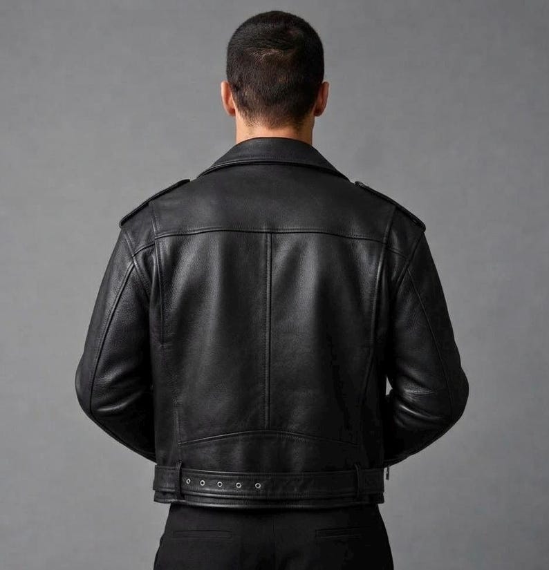 May include: A black leather motorcycle jacket featuring a classic fold-down collar, shoulder epaulets, and a horizontal back yoke. The jacket includes a buckled belt at the waist with metal eyelets and long sleeves, shown from the back view.