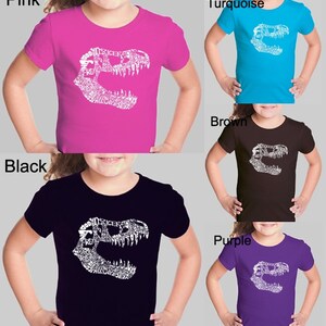 Girl&#39;s T-shirt - T-Rex skull created out of popular Dinosaur names.