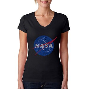 May include: Black V-neck t-shirt with a blue and red NASA logo made of words. The logo is a circle with a red swoosh and the word "NASA" in white letters.