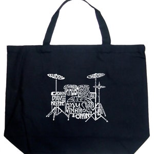 May include: Black canvas tote bag with a white graphic of a drum set. The drum set is made up of the names of famous drummers, including Buddy, Charlie, Stewart, Jojo, Roger, John, Ringo, Alex, Dave, Ginger, Keith,  and more.