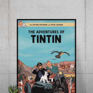 May include: A framed movie poster for The Adventures of Tintin featuring Tintin, Captain Haddock, and Snowy in a sidecar motorcycle. The text reads From Steven Spielberg and Peter Jackson, The Adventures of Tintin, with a desert town background.