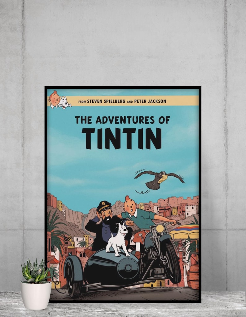 May include: A framed movie poster for The Adventures of Tintin featuring Tintin, Captain Haddock, and Snowy in a sidecar motorcycle. The text reads From Steven Spielberg and Peter Jackson, The Adventures of Tintin, with a desert town background.
