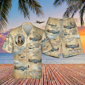May include: A tan button-up shirt and matching shorts set featuring a vintage map design with fighter planes and text. The shirt has a portrait of Chuck Yeager. The shorts and shirt have text that reads "RAF Leiston, England" and "Berlin, Germany".