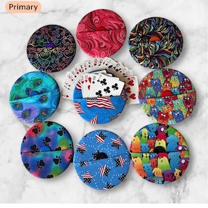 May include: A white ceramic mug with a black handle and the text "But First, Coffee" in a bold, black font. The mug is set against a blurred background, suggesting a cozy setting.