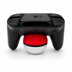Puede incluir: Un mando de videojuegos negro con una base de Pok&eacute; Ball roja, blanca y negra. El mando tiene botones etiquetados ZL y ZR. La Pok&eacute; Ball tiene aproximadamente 7,6 cm de di&aacute;metro.