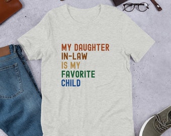 May include: A heather grey t-shirt with the text "MY DAUGHTER IN-LAW IS MY FAVORITE CHILD" in colorful block letters.