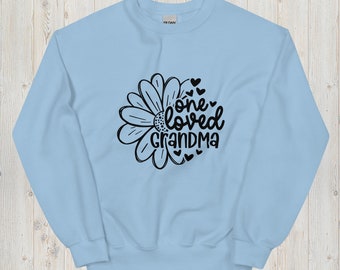 May include: Light blue sweatshirt with a black daisy and the text "one loved grandma" with small hearts.