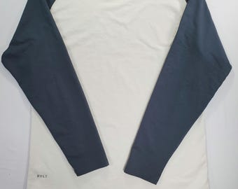 Camiseta raglán de corte bajo BYLT, talla L, color crema y verde, manga larga, estilo athleisure minimalista.