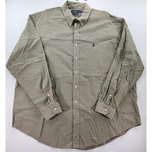 Könnte beinhalten: Langärmeliges Button-Down-Hemd mit kleinem Karomuster in Braun- und Beigetönen. Das Hemd hat einen Button-Down-Kragen, eine Brusttasche mit kleinem gesticktem Logo und geknöpfte Manschetten.