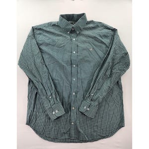 Könnte beinhalten: Langärmliges Hemd mit teal- und marineblauem Karomuster. Es hat einen Button-Down-Kragen, geknöpfte Manschetten und ein kleines gesticktes Logo auf der Brust. Das Hemd ist aus leichtem Stoff. Maße in Zentimetern.