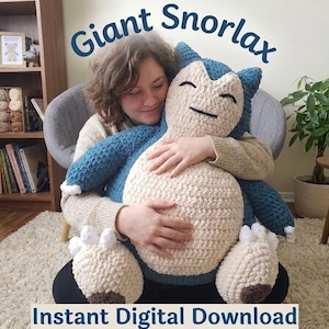 Könnte beinhalten: Ein riesiges, handgefertigtes Snorlax-Plüschtier in Creme, Blau und Braun. Das Plüschtier hat ein lächelndes Gesicht und wird gehalten. Der Text "Giant Snorlax" und "Instant Digital Download" sind sichtbar.