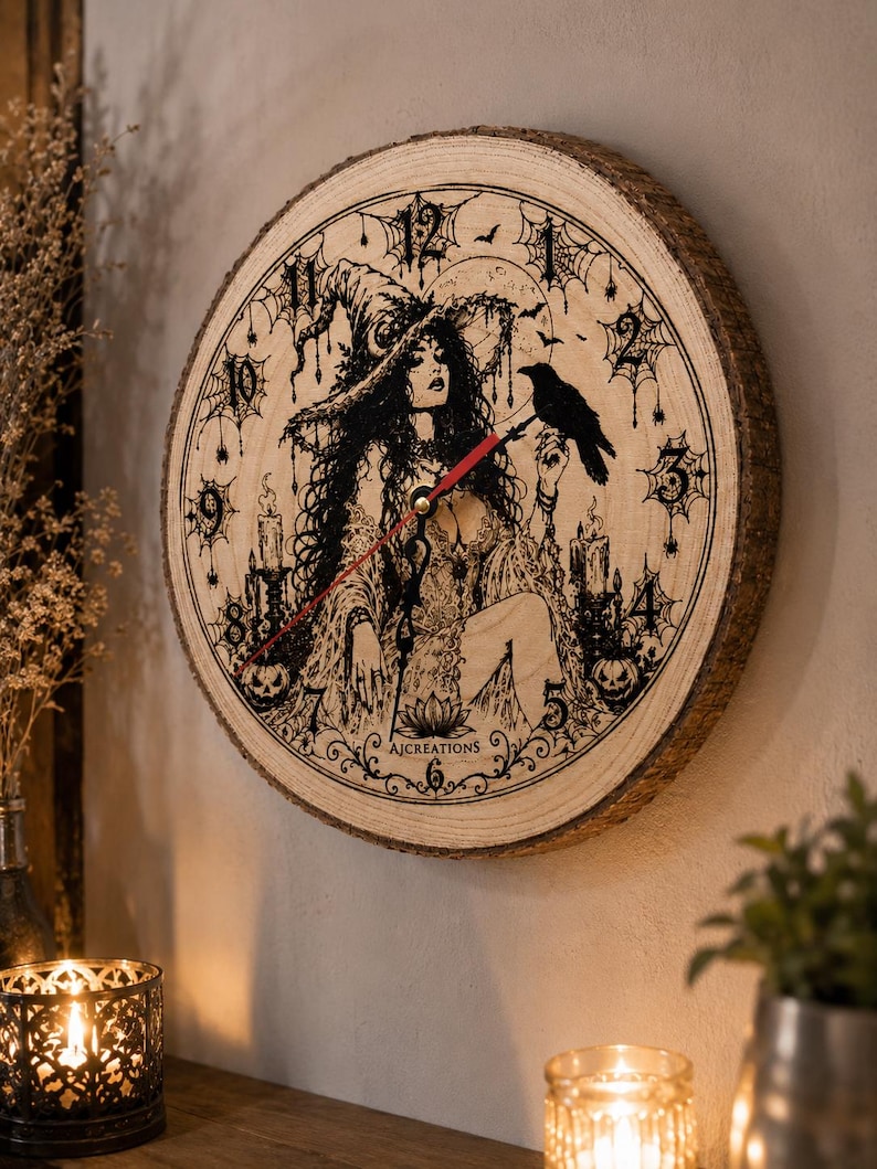 Pu&ograve; includere: Un orologio da parete rotondo realizzato con una fetta di legno naturale con bordi in corteccia. Il quadrante presenta un'illustrazione a inchiostro nero di una strega con un corvo, candele, zucche e ragnatele. Ha lancette nere e una rossa.