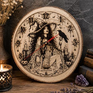 Pu&ograve; includere: Un orologio da parete rotondo ricavato da una fetta di legno naturale con un'illustrazione pirografata di una strega con cappello a punta, un corvo, ragnatele, candele e zucche. Il quadrante presenta numeri neri e lancette sottili rosse e nere.