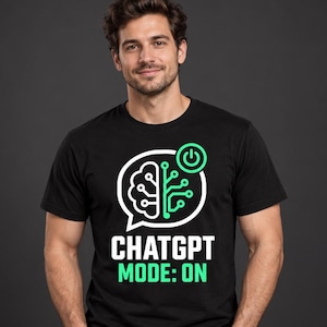 May include: A black short-sleeved t-shirt featuring a graphic of a speech bubble containing a brain on the left and a circuit board pattern on the right. Above the bubble is a power button icon. The text reads CHATGPT MODE: ON in white and green.
