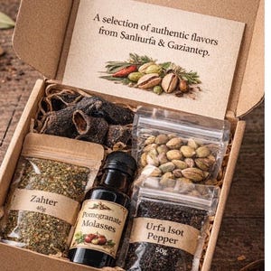 May include: A wooden gift box filled with authentic flavours. It contains a bottle of pomegranate molasses, bags of Zahtar (40g) and Urfa Isot Pepper (50g), and other spices. The box also has a card that reads "A selection of authentic flavours from Şanlıurfa & Gaziantep."