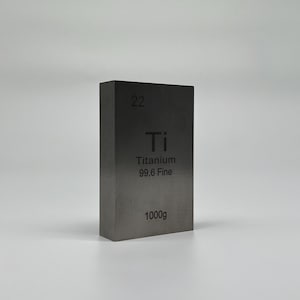 Könnte beinhalten: Ein rechteckiger Titanblock mit der Zahl "22" oben. Darunter das Elementsymbol "Ti", das Wort "Titanium" und "99.6 Fine". Auf der Unterseite des Blocks steht "1000g".
