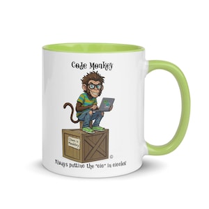 Può includere: Tazza in ceramica bianca con interno e manico verdi. La tazza presenta una scimmia dei cartoni animati con gli occhiali e un laptop, con il testo "Code Monkey" e "Always putting the 'eie' in circles."