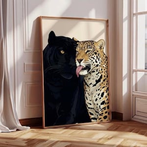 Puede incluir: Impresión artística enmarcada que representa una pantera negra y un leopardo. La pantera está a la izquierda, el leopardo a la derecha, sacando la lengua. El leopardo tiene un pelaje beige con manchas negras. El marco es de color marrón claro.
