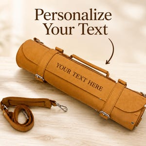 Könnte beinhalten: Eine hellbraune Leder-Messertasche mit Griff und Schultergurt. Der Text "YOUR TEXT HERE" ist auf der Vorderseite eingraviert. Die Worte "Personalize Your Text" stehen oben.