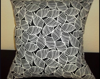 May include: Black and white throw pillow with a leaf pattern. The pillow is made of a soft, comfortable fabric and has a zipper closure.