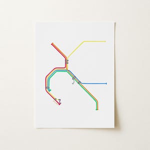 May include: A white rectangular print featuring a stylized transit map design. The graphic consists of intersecting lines in vibrant red, yellow, green, and blue, punctuated by small white circular station markers along the various colored routes.