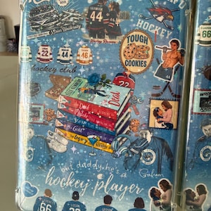 May include: A clear phone case with a blue background featuring hockey-themed graphics and text. The design includes images of hockey players, books, and the text "but daddy he's a hockey player."