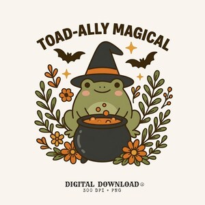 May include: A graphic illustration of a green frog wearing a black witch hat with an orange band, sitting behind a black cauldron filled with orange liquid. The design includes orange flowers, green leaves, two bats, stars, and the text TOAD-ALLY MAGICAL.