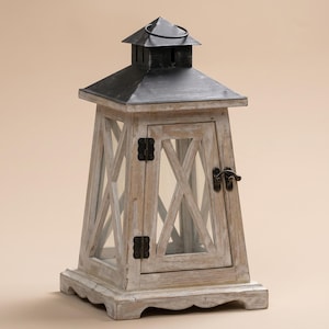 May include: A rustic wooden lantern with a black metal top and handle. The lantern features a distressed white finish, glass panels, and a small door with a latch. The design includes decorative X-shaped accents on the sides.