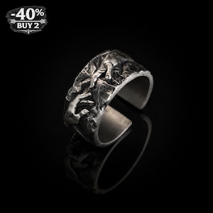 May include: A silver-toned ring with a textured surface, featuring a sculpted design of two hands reaching towards each other. The ring has an open design and is set against a black background. The image also includes a graphic with the text "-40%" and "BUY 2".