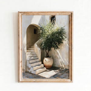 Pode incluir: Pintura emoldurada que retrata um pátio ensolarado com uma escadaria que leva a uma porta arqueada. Uma oliveira em vaso fica ao lado da escada. A obra de arte apresenta uma paleta de cores neutras com sombras e destaques.