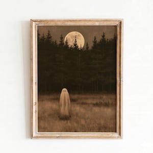 Puede incluir: Una lámina de arte enmarcada que muestra un paisaje en tonos sepia con una figura fantasmal alta, blanca y cubierta por una sábana, de pie en un campo de hierba. Al fondo, un bosque oscuro se recorta contra una gran luna llena pálida.