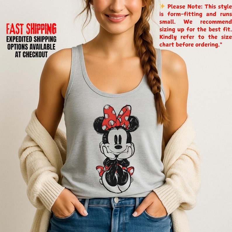 May include: A light gray tank top featuring a Minnie Mouse graphic. The cartoon Minnie Mouse is in black and white with a red bow and accents. The text on the shirt says, "Please Note: This style is form-fitting and runs small."