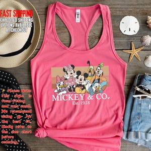 Puede incluir: Camiseta sin mangas rosa con un gr&aacute;fico de Mickey Mouse y sus amigos. El dise&ntilde;o incluye a Minnie Mouse, Donald, Daisy, Goofy y Pluto. El texto "Mickey & Co. Est. 1928" est&aacute; impreso debajo de los personajes.