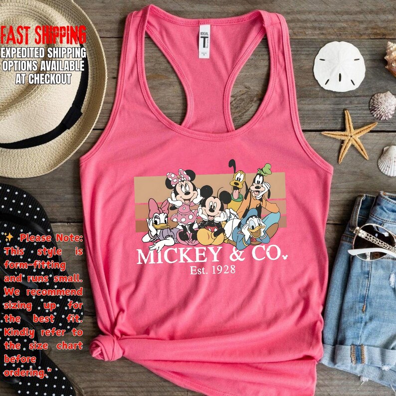 Puede incluir: Camiseta sin mangas rosa con un gr&aacute;fico de Mickey Mouse y sus amigos. El dise&ntilde;o incluye a Minnie Mouse, Donald, Daisy, Goofy y Pluto. El texto "Mickey & Co. Est. 1928" est&aacute; impreso debajo de los personajes.