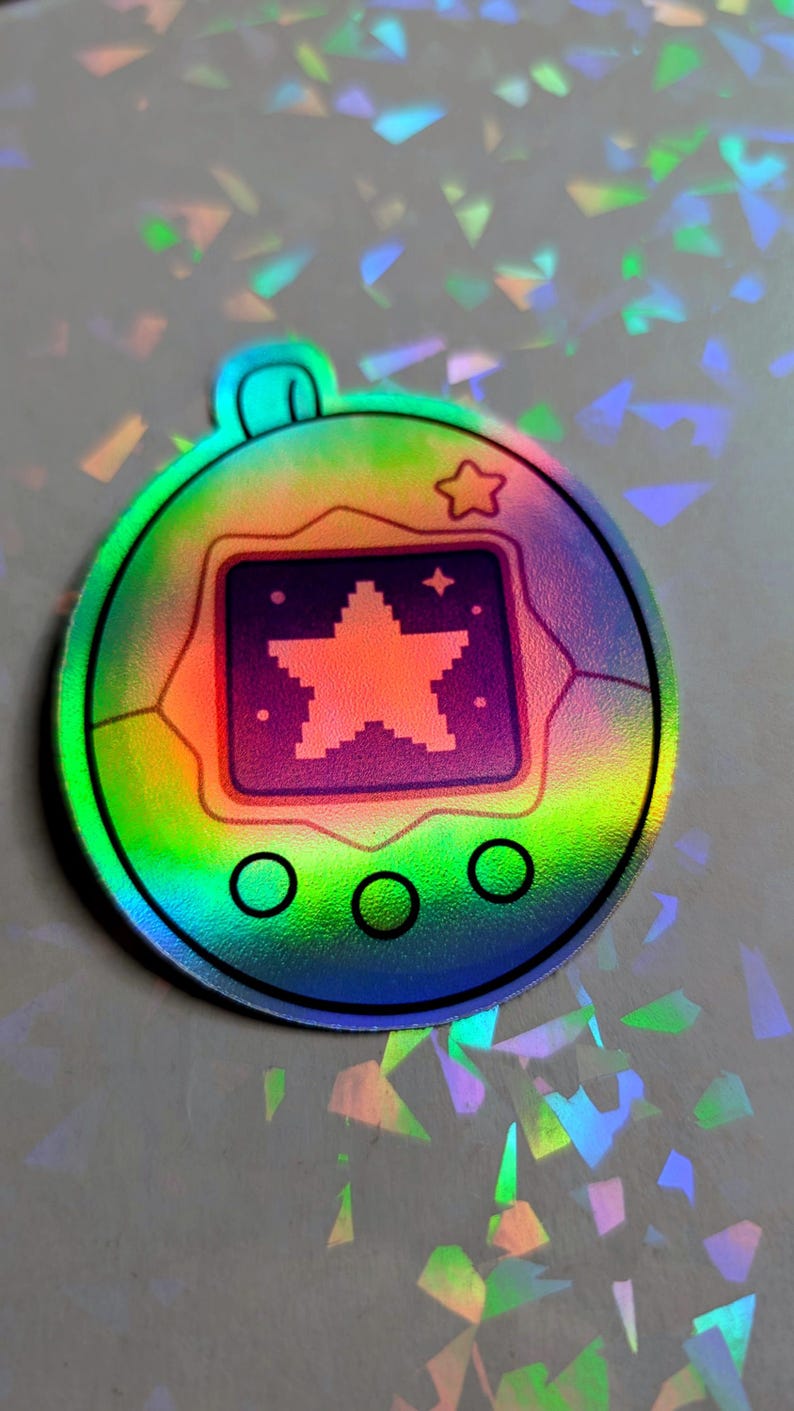 May include: Holographic sticker featuring a pixelated star design within a square, surrounded by a circular frame. The sticker has a rainbow color scheme with a star and three circles at the bottom. A small star is at the top.