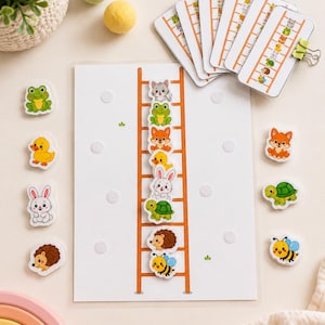 Op de afbeelding: Een educatief spel voor kinderen met een wit bord en een oranje ladder. Het spel bevat diervormige magneten zoals een kikker, eend, konijn, egel, bij, kat, vos en schildpad, plus bijpassende kaarten.