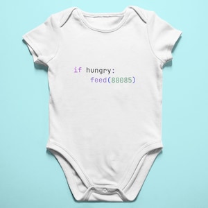 May include: White baby bodysuit with the text "if hungry: feed(80085)" in purple and green. The onesie is made of soft material and has a snap closure at the bottom. The background is a light blue.