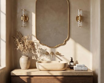 May include: A bathroom vanity featuring a gold-framed mirror, wall lights, and a vessel sink. The wooden vanity cabinet has horizontal grooves. A vase with dried flowers and white towels are on the countertop.