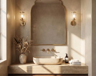 May include: A contemporary bathroom scene featuring a large, arched mirror and two wall-mounted lights. The vanity unit has a stone worktop, a vessel sink, and a wooden cabinet. A vase of dried flowers and a soap bottle are on the counter.