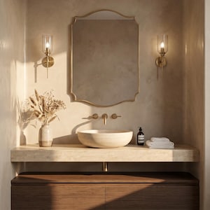 Gold brass mirror above modern bathroom vanity