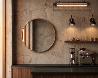 May include: A kitchen interior featuring dark wood cabinetry, a black countertop, and two wooden stools. A round gold-framed mirror hangs on a textured concrete wall above the counter, alongside two black wall sconces and a metal cage pendant light.