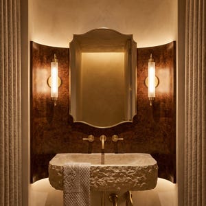 Brass scalloped mirror with warm vanity lighting