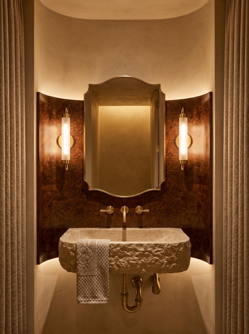 Brass scalloped mirror with warm vanity lighting